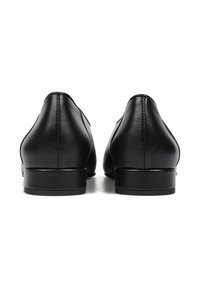 Czarne skórzane buty o gładkiej fakturze, zaokrąglonych obcasach i minimalnych detalach przeszycia. Projekt jest elegancki i nowoczesny.
