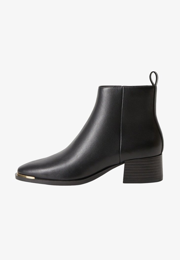 Zwarte leren enkelboot met een spitse neus, korte blokhak, lus aan de achterkant en een metallic accent op de neus. Gladde textuur.