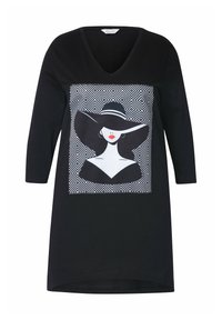 Tunica nera con maniche tre quarti, caratterizzata da una grafica bianca di una donna in un ampio cappello su uno sfondo decorato. Design a scollo a V.