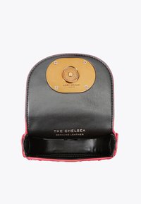 Petit sac à main en cuir noir avec un intérieur et un fermoir magnétique en ton doré gravé "Kurt Geiger" et le texte "The Chelsea Genuine Leather."