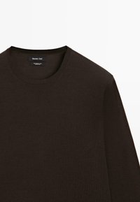 Pull col rond en laine mérinos marron foncé de Massimo Dutti, montrant le haut du torse et les détails de l'encolure.