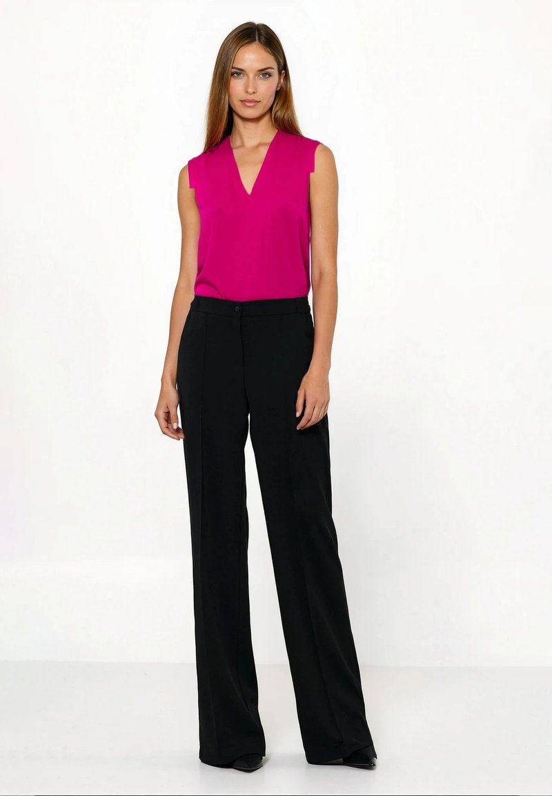 Fuksjowy top bez rękawów z dekoltem w kształcie litery V, połączony z wysokim stanem czarnych spodni o szerokich nogawkach. Gładka tekstura i dopasowany krój.