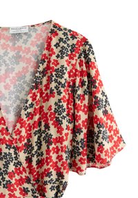 Abito a portafoglio floreale con sfondo beige, caratterizzato da motivi floreali rossi e neri. Tessuto morbido, maniche corte con bordi arricciati e scollatura a V profonda.