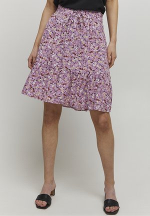 Fioletowa spódnica w kwiaty z falbaniastym, warstwowym dołem, elastycznym paskiem w talii i lekkim materiałem. Detale obejmują różnorodne małe, kolorowe kwiaty.