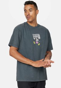 Šedé bavlněné tričko se předním potiskem Mickey Mouse v fialových šortkách a žlutých botách. Krátké rukávy a kulatý výstřih.