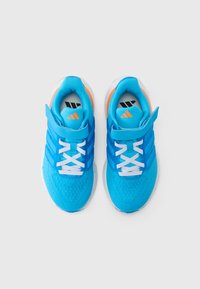 Pantofi sport albaștri cu partea superioară texturată, șireturi albe și o curea cu Velcro. Prezintă accente portocalii și o talpă exterioară albă cu pete.