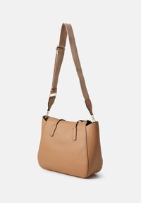 Sac à main en simili cuir beige avec une surface texturée, doté d'une large ouverture, de poignées supérieures doubles et d'une bandoulière amovible et réglable.