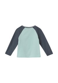 Lichtblauwe langeslakshemd met marineblauwe raglanmouwen. Zachte katoenstof met een ronde hals en contrasterende stikseldetails.