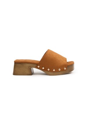 Sandalia de ante marrón tipo slide con punta abierta, tacón cuadrado y tachuelas metálicas decorativas a lo largo del lateral. Presenta una suela texturizada.