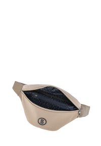 Borsa a vita beige con una superficie liscia, chiusura con zip e accento del logo. Interno con rivestimento nero e branding ripetuto. Design compatto.