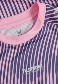Close-up of a pink and purple striped sports shirt collar with "hummel PERFORMANCE" logo printed on the front.
