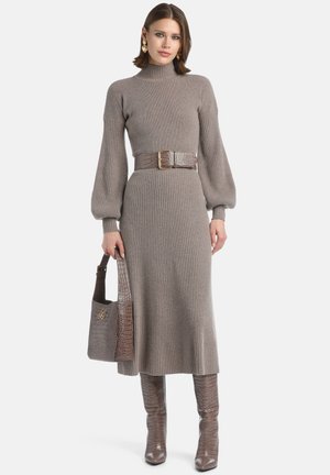 Knit dress in light brown with a high neck and ribbed texture, featuring long sleeves, a wide belt, and matching croc-embossed accessories.