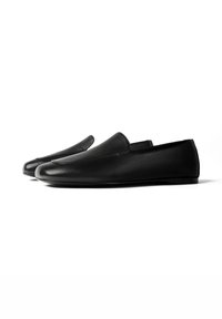 Μαύρα δερμάτινα loafers χωρίς κορδόνια, με στρογγυλεμένες μύτες και επίπεδες σόλες, τοποθετημένα δίπλα-δίπλα σε λευκό φόντο.