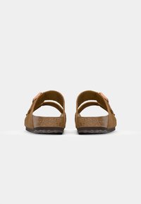 Bruna mockaskor med dubbla remmar och justerbart spänne, med en korkfotbädd och texturerad svart gummisula.