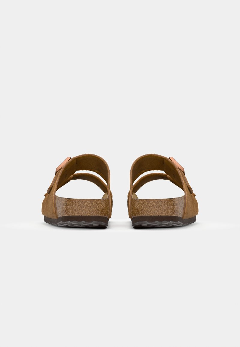 Sandales en suède marron avec des doubles sangles et une boucle réglable, dotées d'une semelle en liège et d'une semelle extérieure en caoutchouc noir texturé.