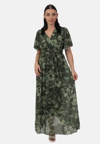 Grünes Blumenkleid im Maxiformat mit kurzen, puffigen Ärmeln, einem Wickelausschnitt und gerafftem Taillenbereich, aus einem leichten, transparenten Stoff gefertigt.