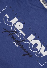 Navyblauwe t-shirt met bedrukt en geborduurd tekst in wit en zwart. Heeft een ronde halslijn en eenTextuurstof.