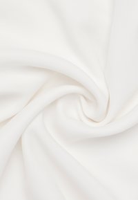 Tessuto bianco con una consistenza liscia e morbida, drappeggiato in morbide pieghe. Il materiale appare leggero e leggermente lucido, senza modelli.
