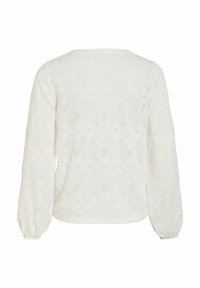 Blouse blanche à manches longues avec motif en dentelle florale et col rond vue de dos.