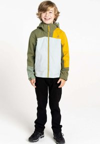 Wasserabweisende Jacke in Grün, Grau und Gelb mit durchgehendem Reißverschluss, verstellbare Kapuze und elastischen Bündchen; kombiniert mit schwarzen Hosen und Schuhen.