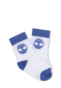 Socks bianchi con un bordo a coste blu, con un logo a forma di albero blu su ciascun lato. Materiale morbido in miscela di cotone con accenti ai piedi in contrasto.