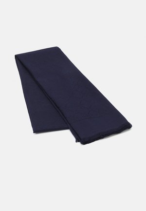 Sciarpa piegata blu scuro con motivo testurizzato sottile e frange corte sui bordi, su uno sfondo bianco semplice.