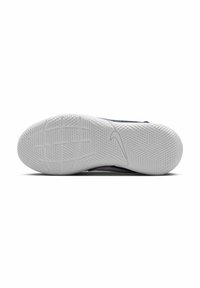 Nike cipőtalp, amely egy struktúrált fehér gumifelszínt tartalmaz, mintázott tapadásvonalakkal és diszkrét logó részletekkel.