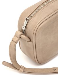 Borsa in pelle beige con una texture liscia, forma rettangolare, chiusura con zip superiore e una tracolla rimovibile. Sono visibili finiture in metallo.