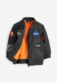 Veste bomber grise avec doublure en polaire orange. Comprend des patchs NASA et à thème spatial. Fermeture éclair et poignets côtelés.