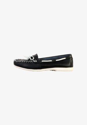 Mocassin en cuir noir avec coutures blanches, nœud blanc sur le dessus et semelle blanche, vu de côté sur fond blanc.