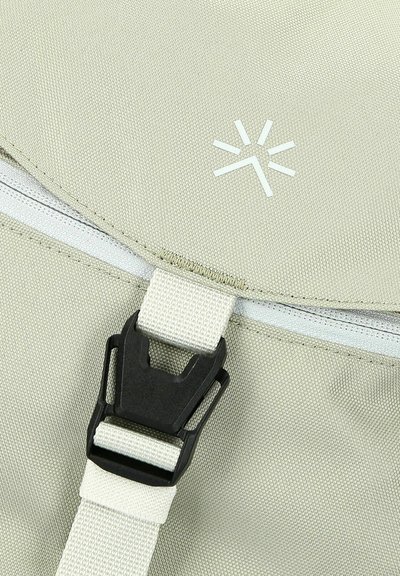 Zaino grigio chiaro con tessuto strutturato, fibbia in plastica nera, cerniera bianca e un design del logo minimalista.