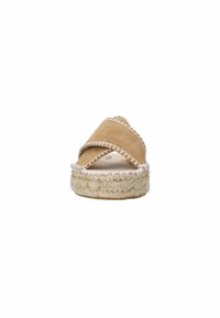 Tan suède espadrille-slides met kruislingse banden, witte stiksels en een gevlochten jute zool. Vlak ontwerp met een ronde neus en een gestructureerd afwerking.