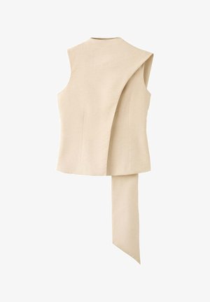Veste beige sans manches avec un panneau avant superposé asymétrique s'étendant en une longue queue pointue en tissu.