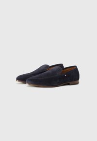 Marineblaue Wildleder-Loafers mit gestickten Details, im Slip-On-Design, und einem kleinen dreifarbigen Logo-Akzent an der Seite. Braune Sohle.