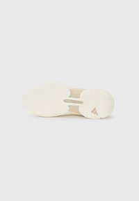 Helle Sport- Schuhsohle mit einem gemusterten Gummi- Griff, ausgestattet mit einem zentralen Ausschnitt und einer strukturierten Oberfläche für Traktion.