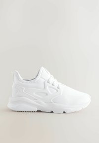 Baskets de sport blanches avec une tige en tissu lisse, des superpositions courbées, des lacets ronds et une semelle texturée pour l'adhérence. Design léger.