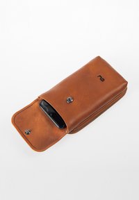 Braune Leder-Handytasche mit Reißverschluss, ausgestattet mit einem Druckknopf und einem sichtbaren Smartphone darin. Glatte Textur, rechteckige Form.
