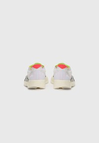 Athletic shoes with a white mesh upper, black stripes, and neon pink and green accents; chunky sole; minimalistic design.