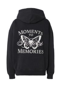 Sudadera con capucha negra con gráfico de mariposa blanca y texto "Momentos para recuerdos" en la espalda en tipografías serif y cursiva.