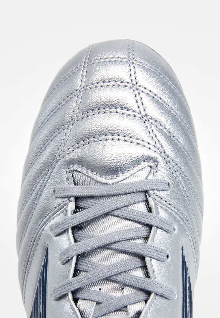 Chaussure de football en cuir argenté avec une surface texturée et matelassée et des lacets gris. Présente des accents bleu foncé sur le côté et une pointe arrondie.