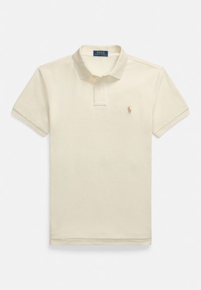 Beige poloshirt med korte ermer, med knappet krage og en liten brodert logo på venstre bryst. Strukturert bomullsmateriale.