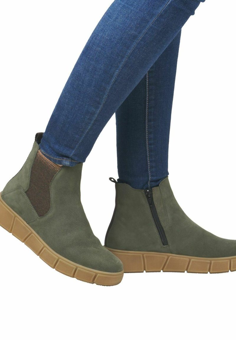 Botas de tobillo de ante verde con paneles laterales elásticos, que cuentan con una cremallera, una suela de goma gruesa y una textura suave.