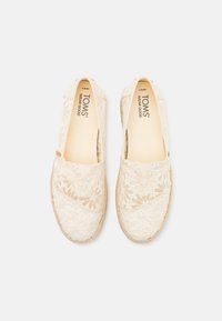 Spets espadrillos i off-white med blommönster, naturlig jutesula, slip-on design, med en mjuk insida och subtil branding.