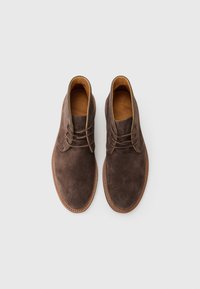 Pair of brown suede lace-up ankle boots with tan leather insoles and stitched edges on a plain white background.