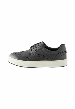 Sort læder brogue sneaker med hvid sål, vingetip-design, perforerede detaljer og sorte snørebånd, vist fra siden på en hvid baggrund.