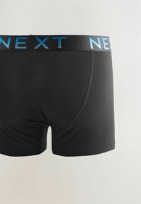 Boxeri negri dintr-un material moale, având un brau cu logo albastru. Designul include o textură netedă și cusături precise pe cusături.