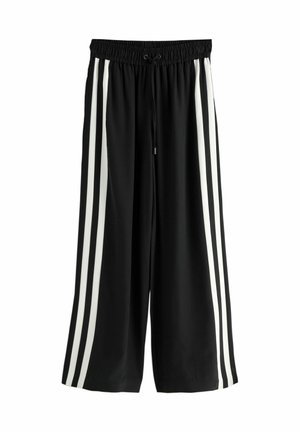 Schwarze Hosen mit weitem Bein und elastischem Bund, jeweils mit zwei vertikalen weißen Streifen an den Seiten. Hergestellt aus weichem, leichtem Stoff.