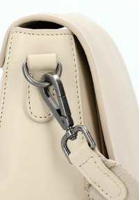 Borsa in pelle beige con lato a chiusura in metallo argentato tipo gancio a polpo attaccato a un anello in pelle e tracolla beige regolabile.