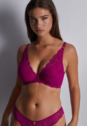 Soutien-gorge en dentelle fuchsia et culotte assortie avec motif floral, décolleté plongeant et bretelles ajustables avec accents en métal doré.
