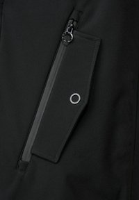 Černá bunda s boční kapsou na zip z texturované látky, stříbrnými doplňky a výrazným kruhovým akcentem u kapsy.
